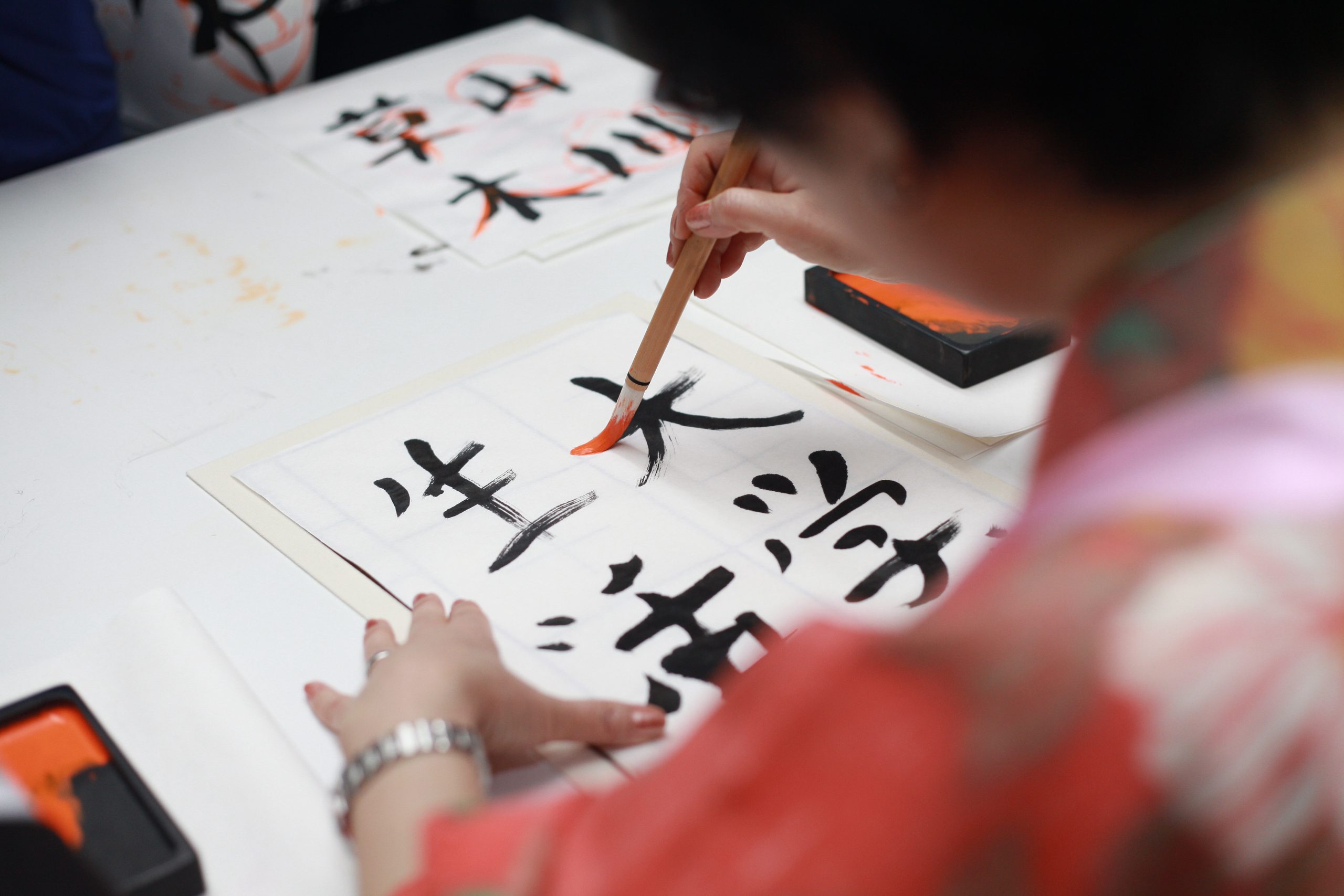 personne tenant un script kanji de dessin au pinceau